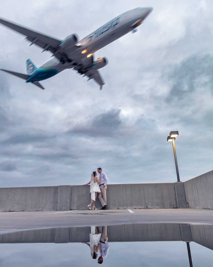 Bride and Groom in Los Angeles, California destination wedding with airplane in background by Olga Gamburg Photography